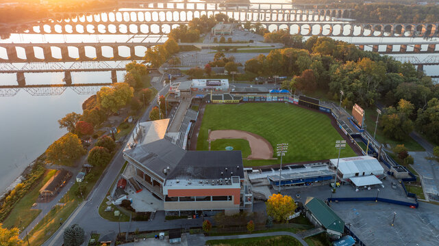 Aerial view of FNB Field in Harrisburg, Pennsylvania, located on an island, with the Susquehanna River and city bridges visible in the background during early morning light.