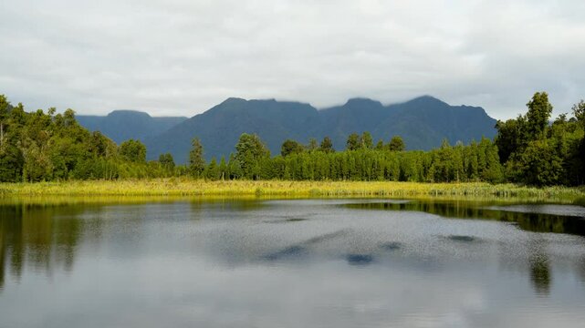 Camera tilt up to reveal Lake Matherson withthe reflection of New Zealands highest peaks