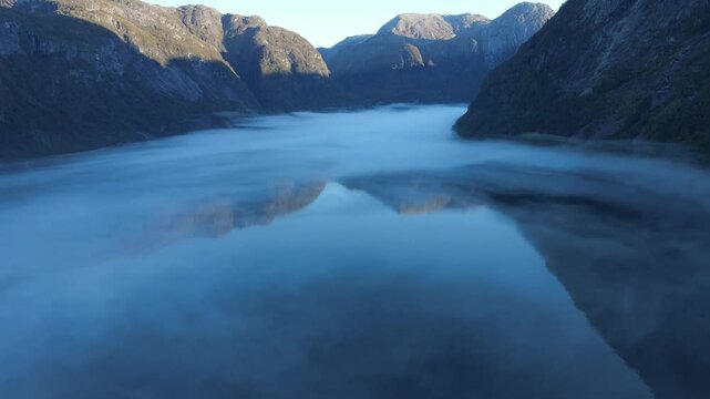 A mist over beautiful fjord of Hardanger in Western Norway. Early morning drone footage