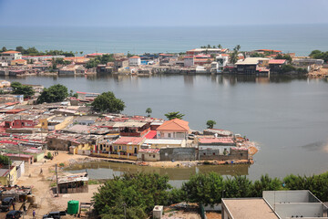Naklejka premium View of coastal neighborhoods along the shoreline of Luanda Angola showcasing urban life beside the water and lush green areas