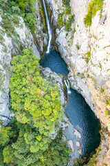 Aerial vertical footage of Velika Gubavica waterfall on the Cetina River in Cetina gorge, canyon in Croatia. Nature background with cascade waterfalls
