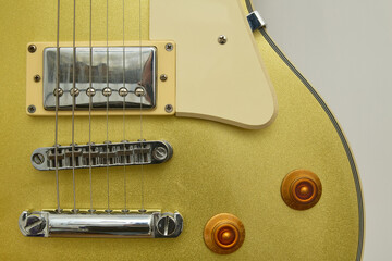 Close-up photograph of a vintage gold-plated electric guitar, details