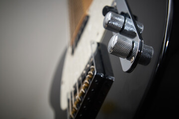 Details of a vintage American electric guitar, black with chrome and maple neck_
