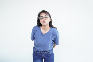 Beautiful Asian woman blows a kiss, her gesture full of warmth and affection, against a white background