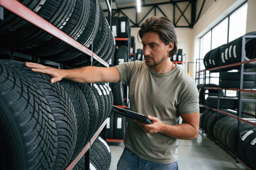Quality control, manager is looking for stuff. Man is in the tire fitting car service