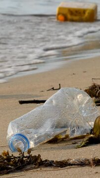 Empty plastic bottles on sand beach. Pollution and environmental problem. Green planet concept