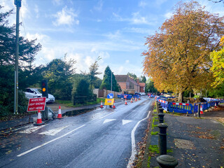 Roadworks with safety barriers and temporary traffic lights in the Tilehurst area of Reading, UK