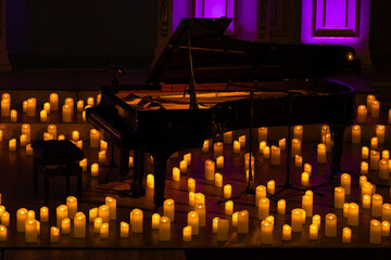 pianoforte on stage with lots of candles