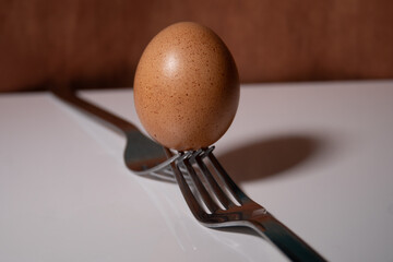 egg balanced on forks