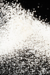 Abstract black and white background of pouring flour, space for text