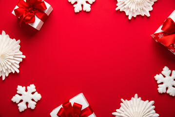 Merry Christmas and Happy Holidays greeting card, frame, banner. New Year. Noel. White, red Christmas ornaments and gifts, presents on red background top view. Winter xmas holiday theme. Flat lay	
