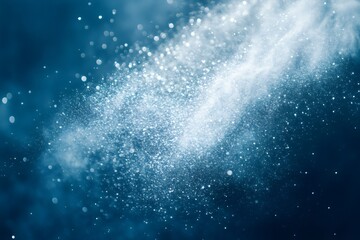 White powder splashing and exploding on blue background creating bokeh and particles for wallpaper and backdrop design