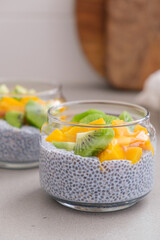 Chia pudding with mango and kiwi in jar. Vegan breakfast concept.