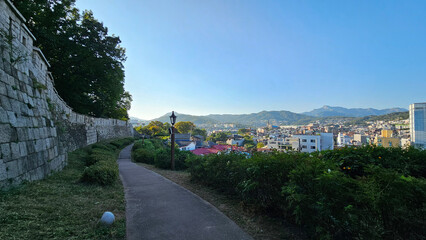 화창한 가을하늘과 나무가 보이는 한양도성 성곽길 담벼락 산책로