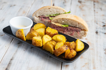 Hamburger cut in halves with potato wedges