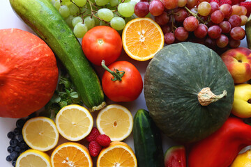 Various seasonal fruits and vegetables on white background. Summer and fall produce. Top view.