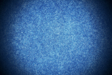 Blue background texture with dark blue vignette. Blue felt canvas fabric background with copy space for design. 