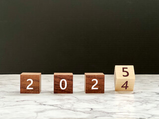 2024から2025に文字が変わる木の立方体_大理石の上