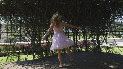 Young woman dancing gracefully in summer park