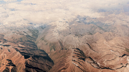 Aerial view of the snow capped Alps, rugged mountain peaks landscape.