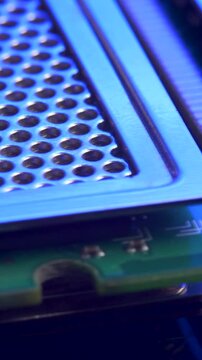 PC memory module with contact pins on blue light mirror surface. Heat spreader transfers energy to heat sink or heat exchanger. Computer hardware concept. Double data rate random access memory