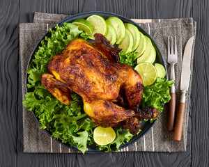 whole roasted chicken with avocado, lime on plate