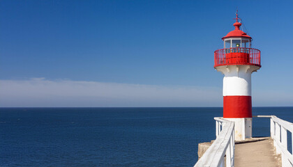 Fototapeta premium Red and White Lighthouse on Top of Pier and Copy Space