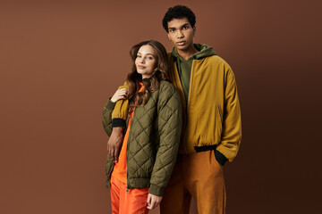 A fashionable young couple embraces seasonal styles with lively autumn attire in a cozy setting.