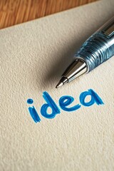 A pen writing the word "idea" on a blank page, with the ink flowing smoothly in a vibrant blue 