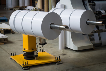 Device for removing finished self-adhesive paper rollers from the rewinding cutting machine