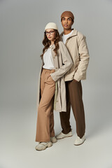 A trendy couple showcases vibrant autumn fashion with stylish layers and accessories.