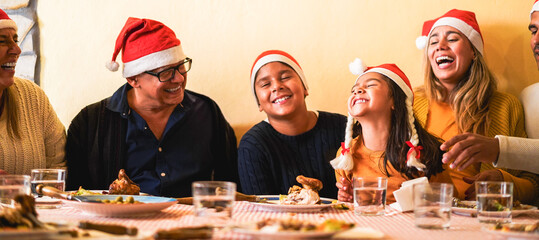 Happy latin family having fun eating together during Christmas time - Holiday concept - Main focus...