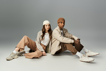 A young couple sits in trendy autumn outfits, radiating style and warmth in vibrant hues.