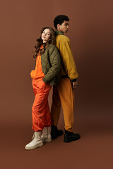 A stylish young couple showcases their autumn fashion with vibrant outfits and cozy layers.