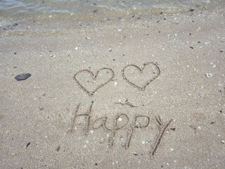 Two hearts drawn on sand beach