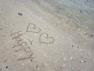 Two hearts drawn on sand beach