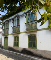 Traditional Colonial House with Green Doors and Balcony
