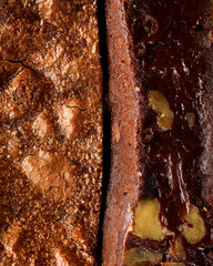 Close-up of a chocolate brownie cut in half, showing a crispy top and a fudgy interior with walnuts. Highlights contrasting textures and rich details. Vertical, Selective focus.