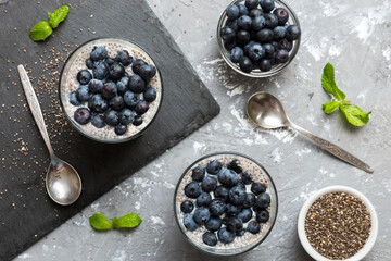 Healthy breakfast or morning with chia seeds vanilla pudding and blueberry berries on table background, vegetarian food, diet and health concept. Chia pudding with coconut milk and blueberry
