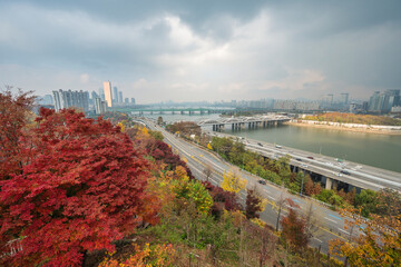 Fototapeta premium Seoul South Korea city skyline at Yeouido Island and Han River view from Yongbongjeong Park in autumn