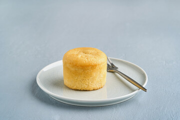 Tasty vanilla white chocolate fondant or lava cake dessert in a plate, on a light blue background. Copy space, closeup view.