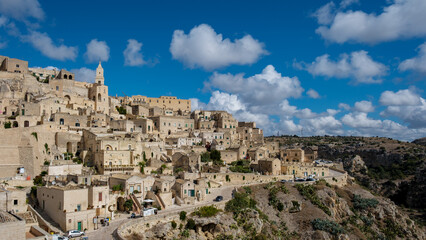 Exploring the stunning ancient architecture of Matera in Puglia, Italy under bright blue skies