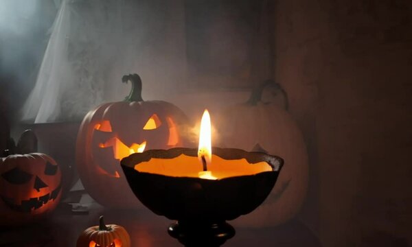 A glowing jack o' lantern with candles, illuminating the dark night with warm, flickering flames, creating a festive and romantic Halloween atmosphere