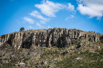 Rocky cliffs in Angola showcasing unique geological formations and vibrant blue sky during daylight