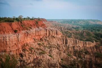 Explore the stunning red cliffs of Angola as they rise dramatically against a clear sky in the late...