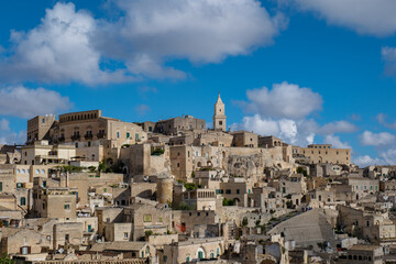 Obraz premium Explore the ancient cave dwellings and stunning landscapes of Matera, Puglia, under a vibrant sky