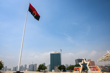 Fototapeta premium A view of Fort San Miguel in Luanda showcasing the Angolan flag and city skyline under a clear blue sky