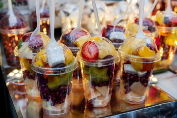 Plastic cups filled with freshly-cut fruits for blending into shakes and smoothies.