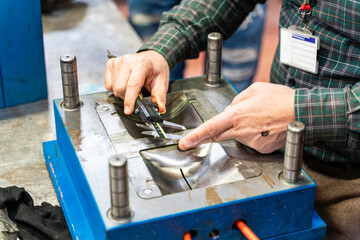 Lathe worker man working with a vernier and milling machine in a factory, using a caliper to check measurement.