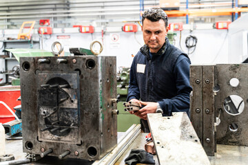 Lathe worker man working with a vernier and milling machine in a factory, using a caliper to check measurement.